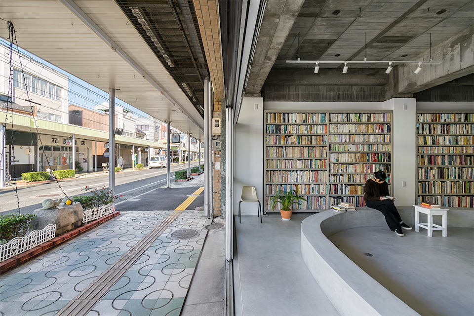 Eine Glastür der öffentlichen Bibliothek im japanischen Ort Tottori verbindet den Innenraum mit der Einkaufsstraße auf eine einladende Art und Weise.