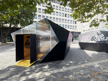 14_Die Ausstellung "WOHNEN EINMAL ANDERS!" auf dem Kesselbrink in Bielefeld. Außenansicht auf die beiden temporären Pavillon-Architekturen aus Holz.<br/><br/>Foto: Patrick Pollmeier<br/><br/>jpg, 7373 × 5529 Pixel