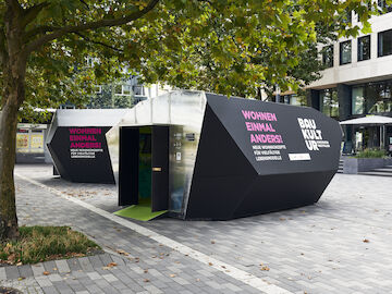 18_Die Ausstellung "WOHNEN EINMAL ANDERS!" auf dem Kesselbrink in Bielefeld. Außenansicht auf die beiden temporären Pavillon-Architekturen aus Holz.<br/><br/>Foto: Patrick Pollmeier<br/><br/>jpg, 7211 × 5408 Pixel