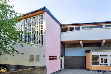 Farbe und Architektur können auf ganz unterschiedliche Weise miteinander in Beziehung treten.  Eine dieser Farbstrategien bezeichnen die Farbforscher vom Haus der Farbe (Zürich) als „Umfassendes Zusammenspiel“.  Farbe ist hier ein untrennbarer Bestandteil der Architektur. Funktion und Nutzung, Konstruktion und Raumproportion, Materialien und Oberflächenstrukturen, Licht und Schatten vereinen sich mit der Farbe zu einer Raumchoreografie. So wie 1962 bei Hans Scharouns Schulbau in Lünen.<br/><br/>Heutige Geschwister-Scholl-Gesamtschule in Lünen, Architekt Haus Scharoun; Foto: © Thomas Robbin<br/><br/>jpg, 5741 × 3827 Pixel