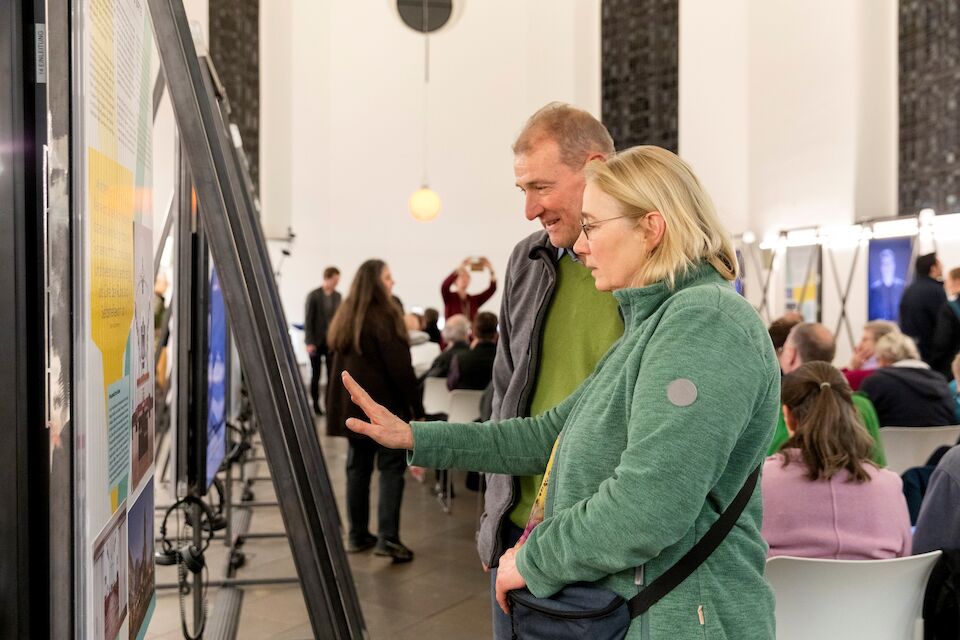 Blick in die Ausstellung „Kirchen als Vierte Orte – Perspektiven des Wandels“ in der Berger Kirche Düsseldorf. Besucher*innen erleben die Videointerviews und Beispiele neuer Nutzungskonzepte leerstehender Kirchen in Nordrhein-Westfalen.